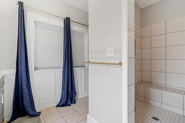 bathroom with tile patterned flooring and a tile shower