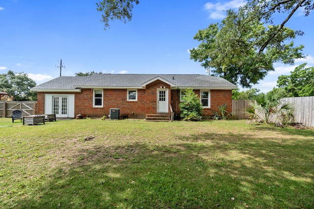 back of property with french doors, central AC unit, and a lawn