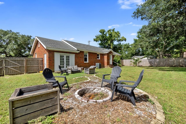 back of house featuring french doors, a yard, and a fire pit