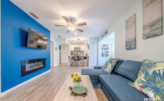 living room with hardwood / wood-style flooring and ceiling fan