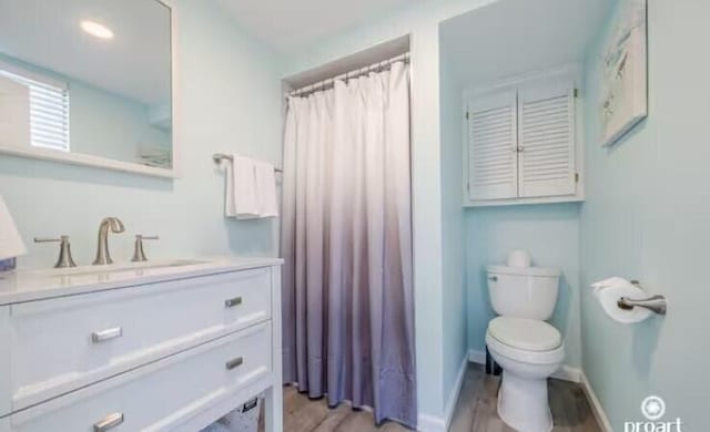 bathroom featuring vanity, hardwood / wood-style floors, a shower with curtain, and toilet