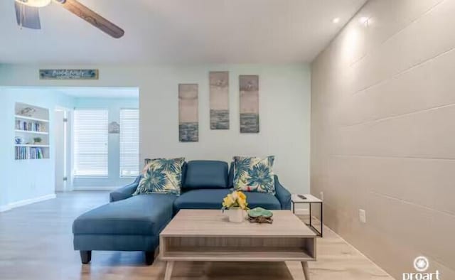 living room featuring ceiling fan and built in features