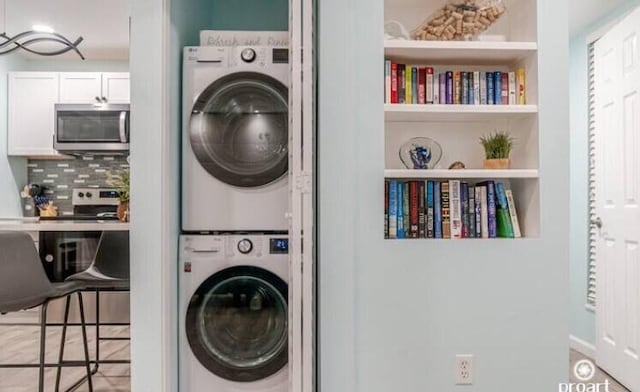 laundry room with stacked washer and dryer and built in features