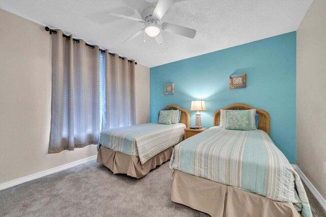 carpeted bedroom with ceiling fan and a textured ceiling