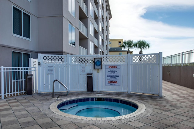 view of swimming pool with a hot tub