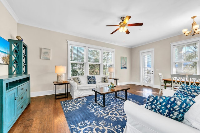 living room featuring ceiling fan with notable chandelier, dark wood-type flooring, ornamental molding, and plenty of natural light