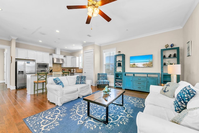 living room with hardwood / wood-style floors, ornamental molding, and ceiling fan