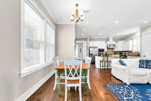 dining space featuring dark wood-type flooring, ornamental molding, and a chandelier