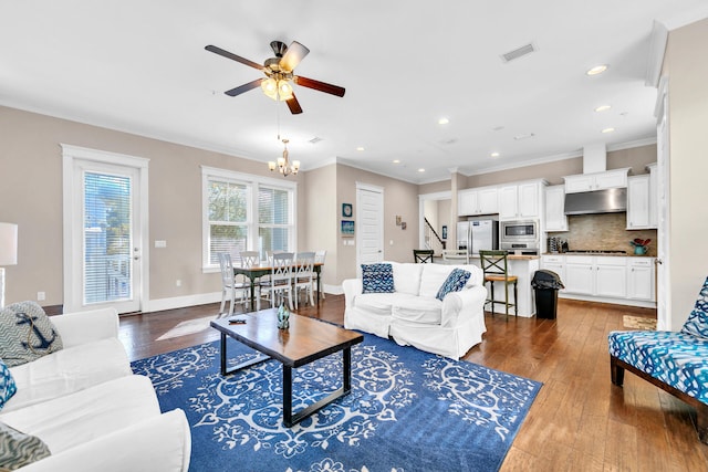 living room featuring crown molding, ceiling fan with notable chandelier, and dark hardwood / wood-style flooring