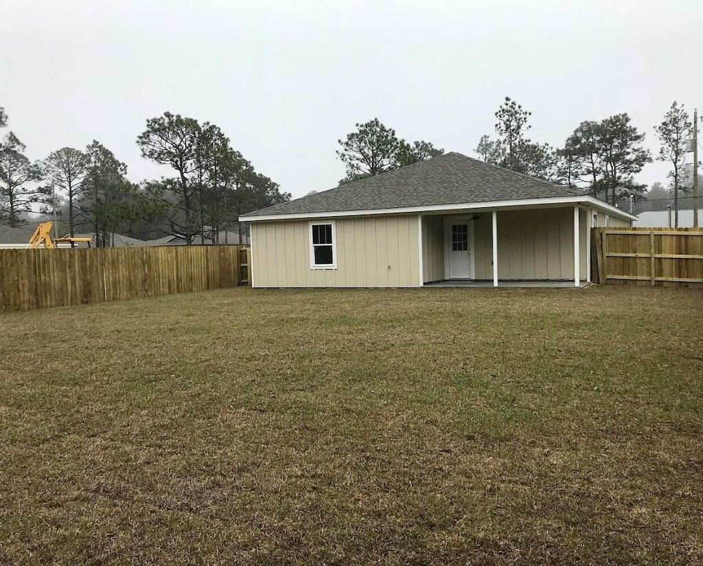 rear view of property featuring a yard