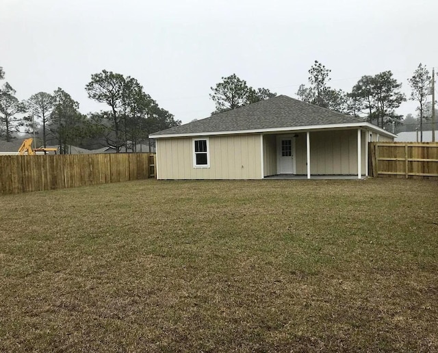 rear view of property featuring a yard