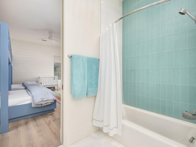 bathroom featuring shower / bath combination with curtain, hardwood / wood-style flooring, and ceiling fan