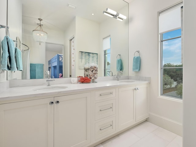 bathroom with tile patterned flooring, vanity, and a notable chandelier