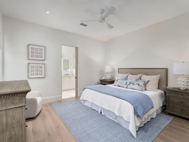 bedroom with connected bathroom, ceiling fan, and light hardwood / wood-style flooring