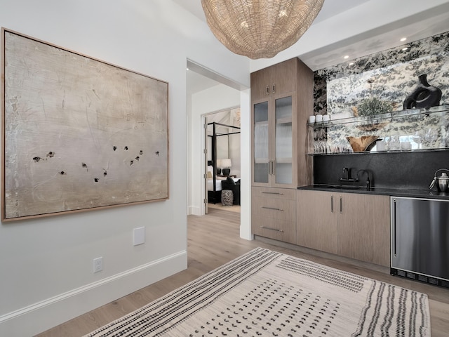 bar featuring light hardwood / wood-style flooring and stainless steel dishwasher