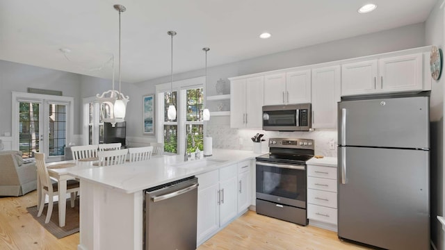 kitchen featuring white cabinets, decorative backsplash, stainless steel appliances, and sink