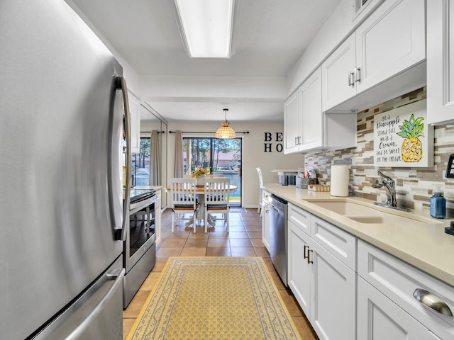 kitchen with white cabinetry, sink, hanging light fixtures, and appliances with stainless steel finishes