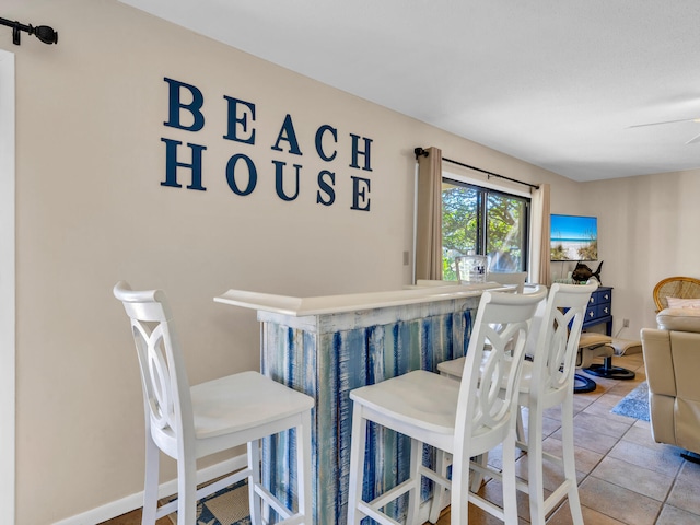 tiled dining space with ceiling fan