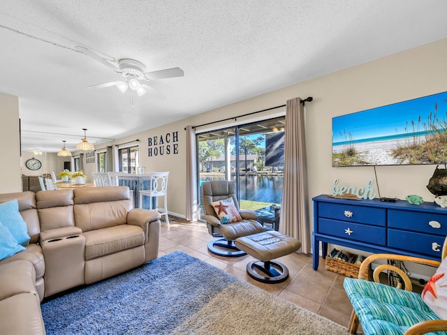 tiled living room with ceiling fan and a textured ceiling