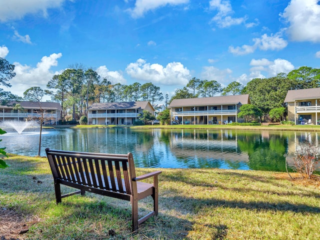 surrounding community with a water view and a yard