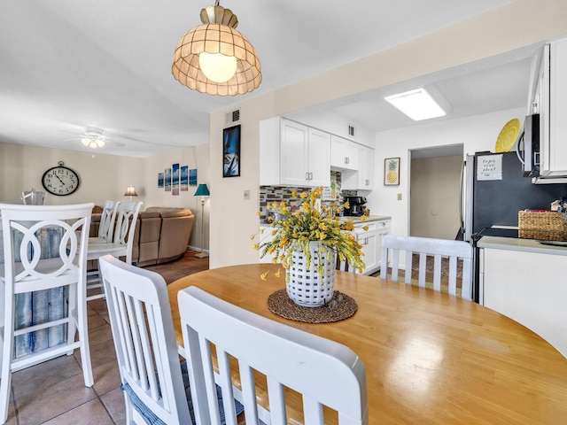 tiled dining room featuring ceiling fan