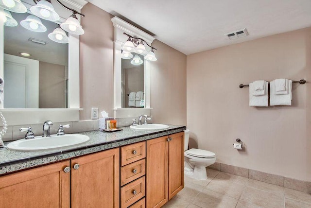 bathroom with double vanity, a sink, visible vents, and tile patterned floors