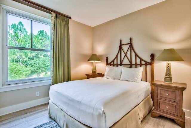 bedroom featuring light wood-type flooring and baseboards