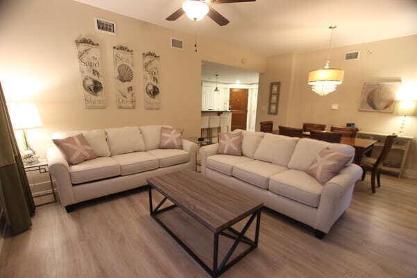 living room featuring dark wood-style flooring, visible vents, and ceiling fan