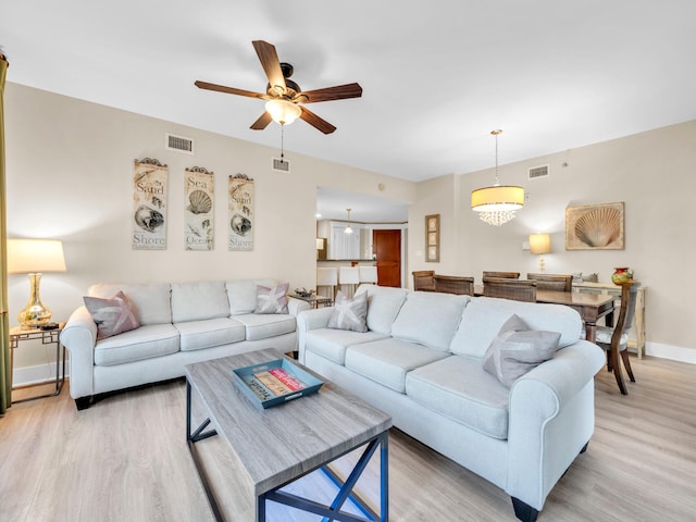 living area featuring visible vents, light wood-style flooring, and baseboards