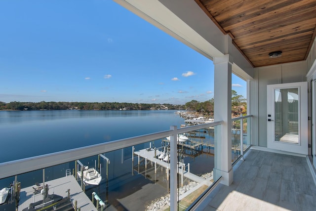 balcony with a dock, a water view, and boat lift