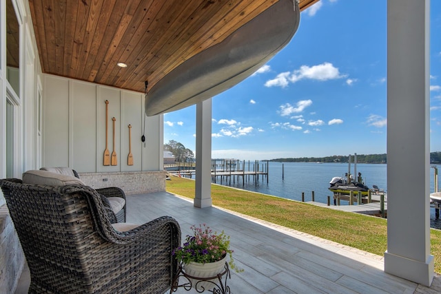 view of patio with boat lift, a boat dock, and a water view