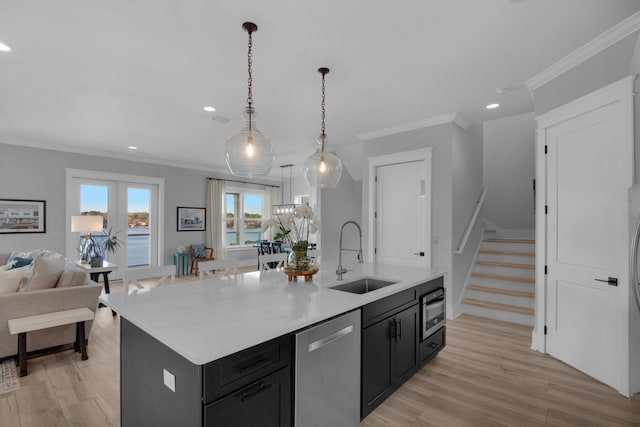 kitchen with a kitchen island with sink, ornamental molding, a sink, dishwasher, and dark cabinets