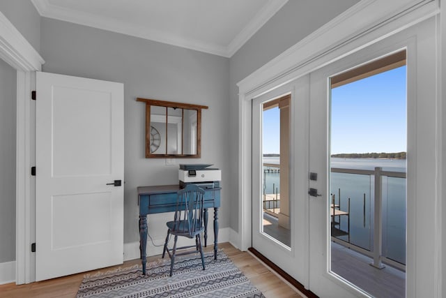 entryway with a water view, ornamental molding, french doors, light wood-style floors, and baseboards