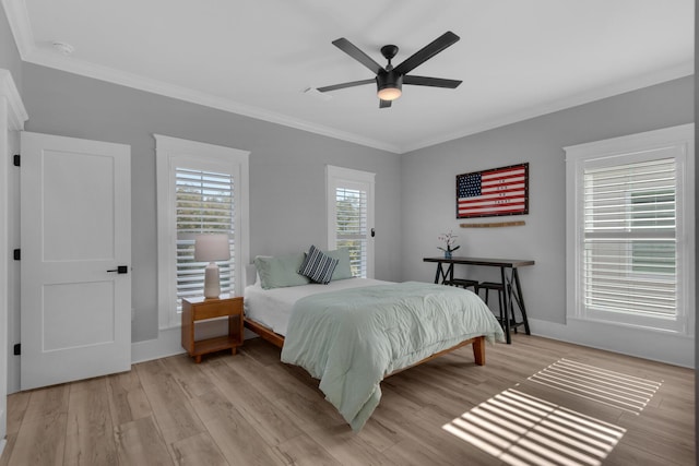 bedroom featuring a ceiling fan, light wood-type flooring, and ornamental molding