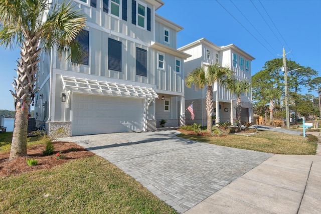 view of front of house featuring decorative driveway, board and batten siding, and an attached garage