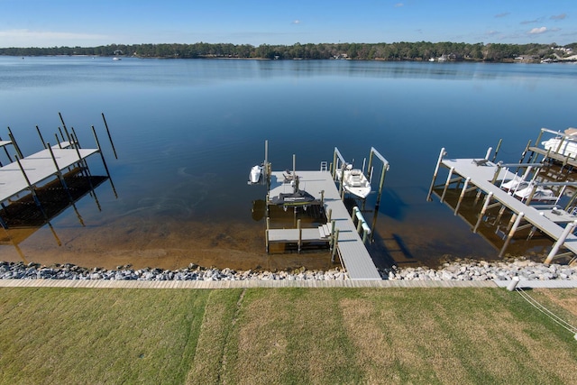 view of dock featuring a lawn, a water view, and boat lift