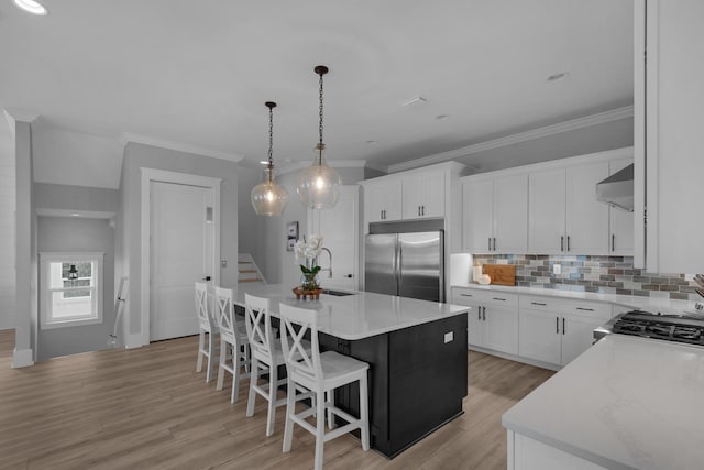 kitchen with decorative backsplash, light countertops, light wood-style floors, and stainless steel built in fridge