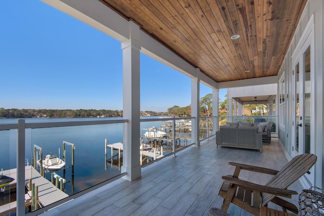 exterior space featuring an outdoor living space, a water view, and a boat dock