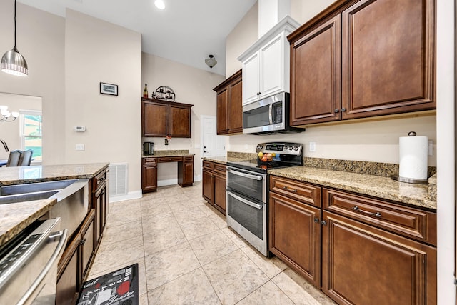 kitchen featuring dark brown cabinetry, stainless steel appliances, an inviting chandelier, and hanging light fixtures