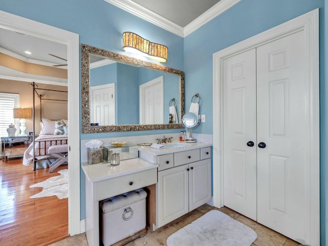 bathroom with hardwood / wood-style floors, vanity, and ornamental molding