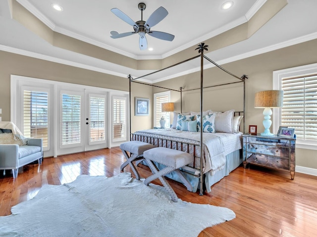 bedroom with ceiling fan, access to exterior, crown molding, and a raised ceiling