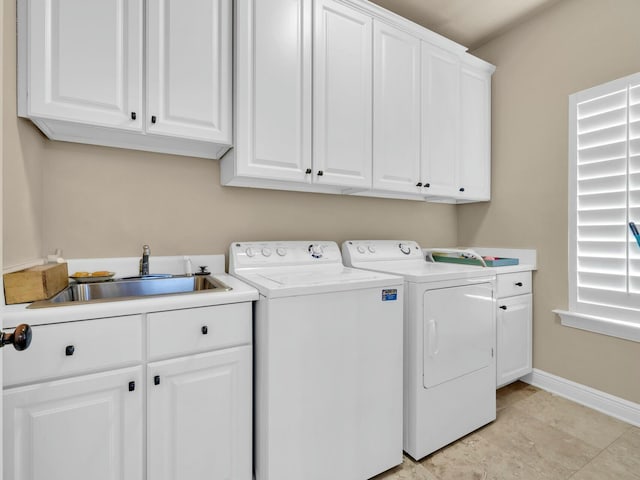 washroom with sink, independent washer and dryer, and cabinets