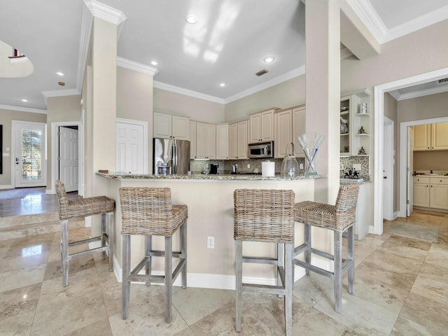 kitchen featuring a breakfast bar area, appliances with stainless steel finishes, and kitchen peninsula