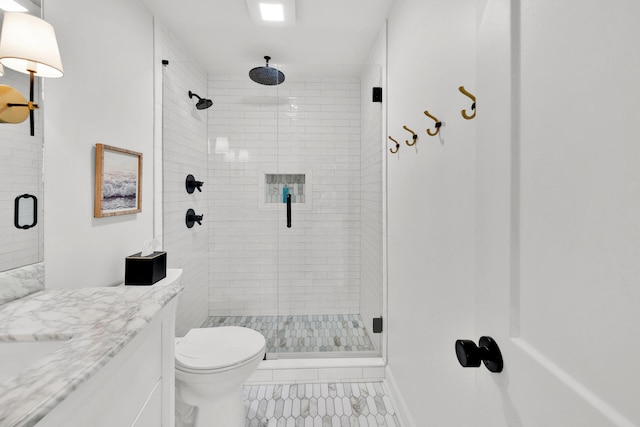 bathroom featuring toilet, a shower with door, and vanity