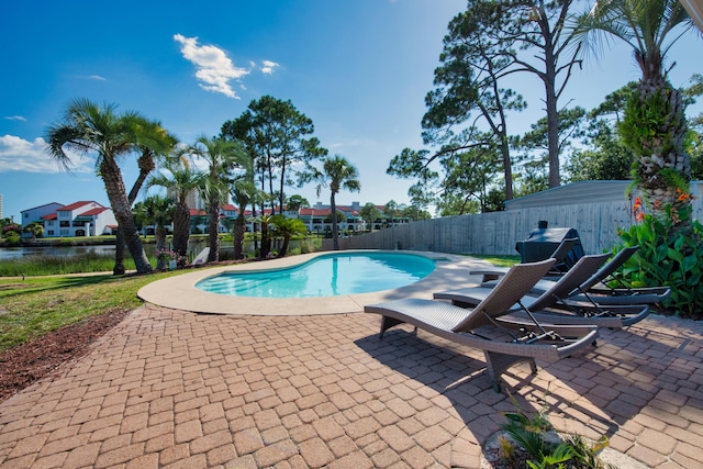 view of pool featuring a patio area and a water view