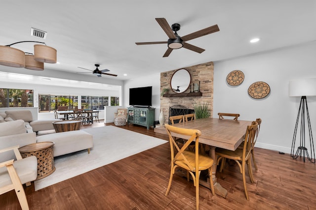 dining space with ceiling fan, a fireplace, and hardwood / wood-style flooring