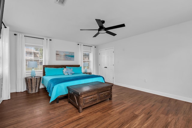 bedroom with dark hardwood / wood-style flooring, a closet, and ceiling fan