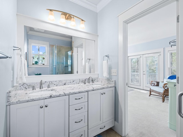 bathroom with crown molding, plenty of natural light, a shower with shower door, and vanity