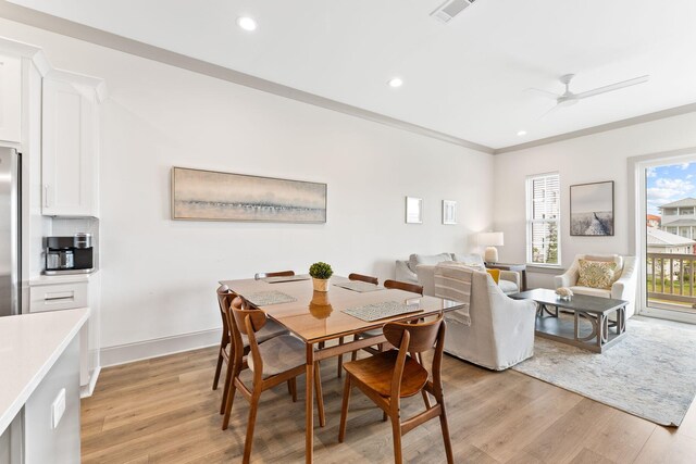 dining area with ceiling fan, ornamental molding, and light hardwood / wood-style flooring