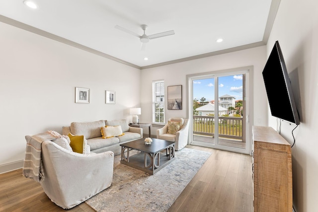 living room featuring light hardwood / wood-style flooring, ceiling fan, and ornamental molding